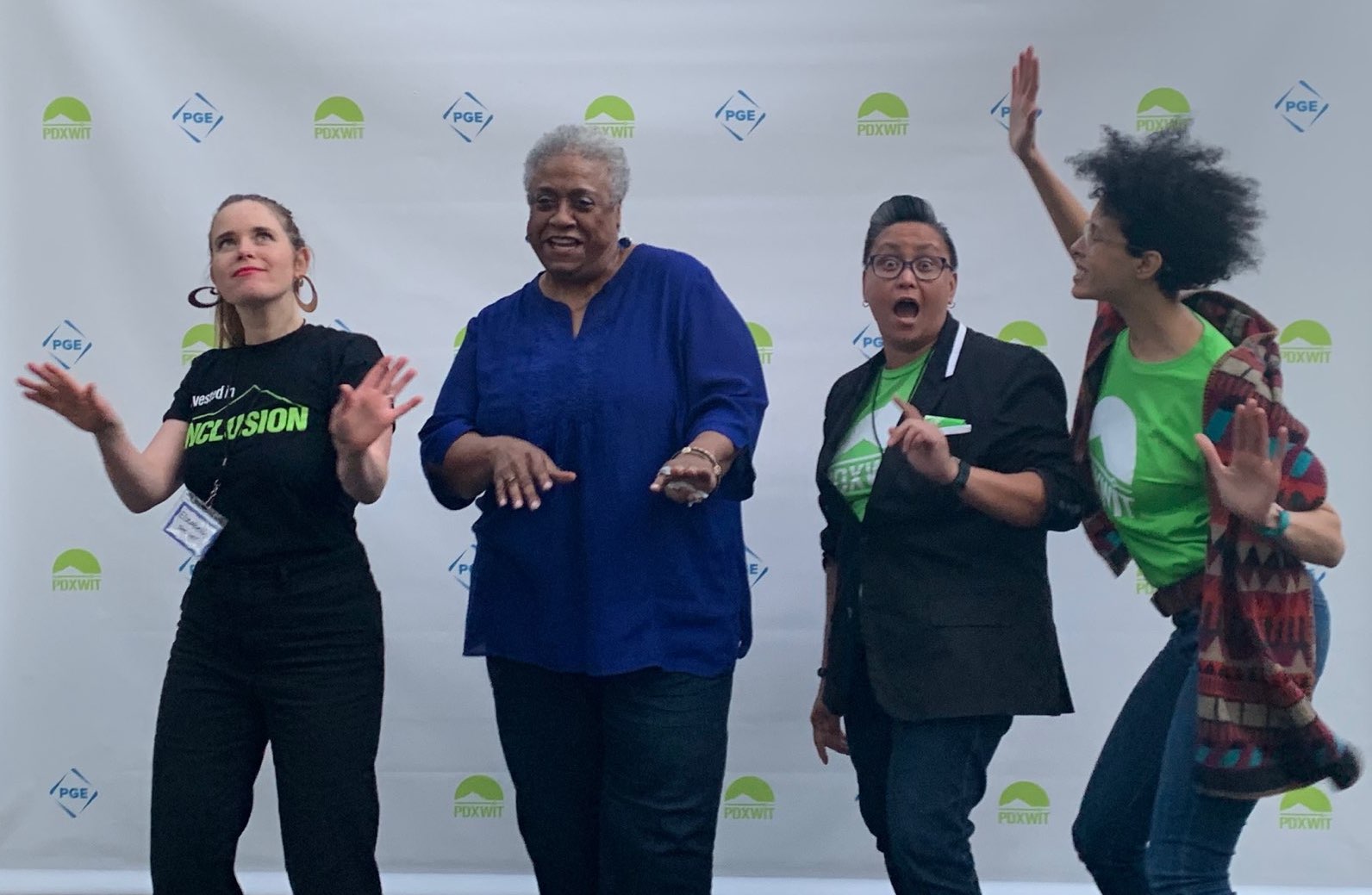 Dawn Mott standing with a group of improv students waving at the camera during the 2019 act-w conference in Portland, Oregon